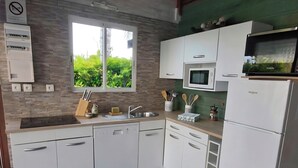 Une cuisine moderne avec des meubles blancs, un four à micro-ondes encastré et un évier.