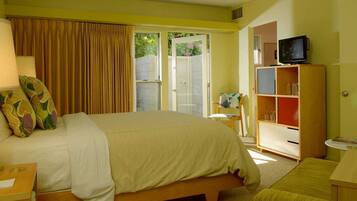 Una habitación de hotel con cama, televisión, estantería y escritorio.