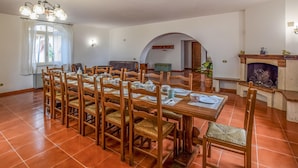 A dining area with a long wooden table set for six, surrounded by wooden chairs with woven seats. - Gorgeous home in Giove (Giove)