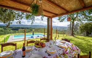A table set for dining with a view of a swimming pool and mountains in the background. - Nice home in Giove with private swimming pool, can be inside or outside (Giove)