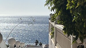 Eine weiße Brüstung führt zu einem Balkon mit Blick auf ein Gewässer.