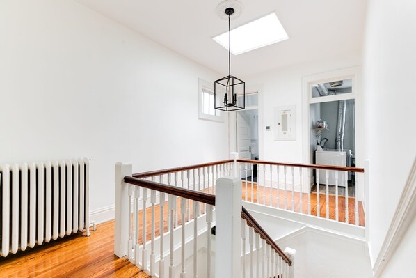 A staircase with white railings and wooden steps leading to an upper floor.