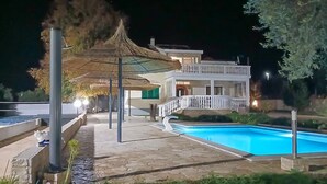 A pool area with a thatched umbrella, a white building with a balcony, and a staircase leading to the entrance. - Pet friendly home in Polaca (Polaca)