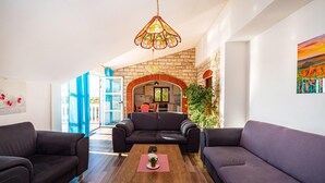 A modern living room with two sofas, a coffee table, and a dining area with a brick archway. - Pet friendly home in Polaca (Polaca)