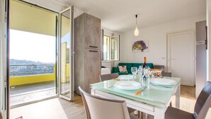 A dining area with a glass table, chairs, and a view through a sliding glass door. - 2 bedroom stunning home in Chiavari (Chiavari)