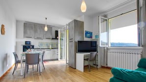 A modern kitchen with a dining area, a TV, and a large window. - 2 bedroom stunning home in Chiavari (Chiavari)