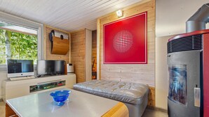 A compact kitchen with a modern design, featuring a built-in oven, a refrigerator, and a dining area with a bench and table. - Amazing home in Zeulenroda-Triebes with sauna (Zeulenroda-Triebes)