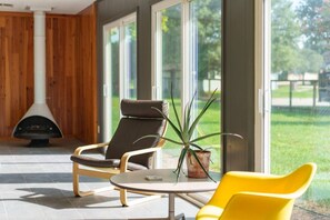 A modern interior with a fireplace, two chairs, a table, and a potted plant. - Trendy & Posh! Your smalltown retreat awaits! (Bellville)
