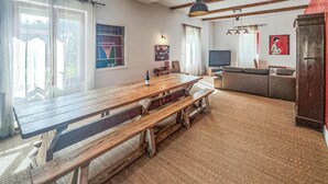 Un salon spacieux avec une table à manger en bois, un canapé et un téléviseur.