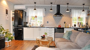 A modern kitchen with white cabinets, a black refrigerator, and pendant lighting. - Stunning home in Karlstad with sauna (Karlstad)