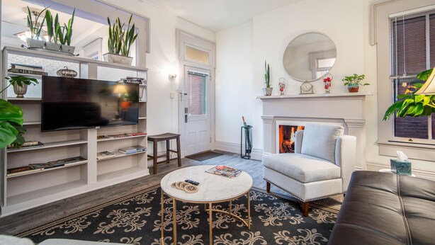 A living room with a fireplace, a television, and a bookshelf.