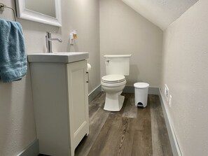 Ein Badezimmer mit Waschbecken, Toilette und Mülleimer.