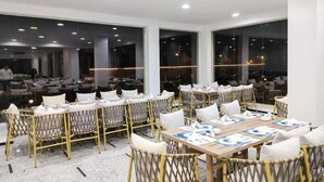 Una sala de conferències amb diverses taules i cadires, grans finestres i un disseny interior modern.