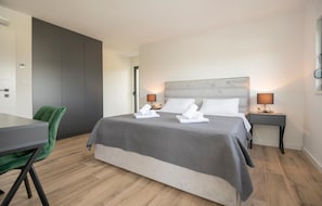 A modern hotel room with a bed, two bedside tables, a desk, and a green chair. - Gorgeous home in Grubine with private swimming pool, can be inside or outside (Grubine)