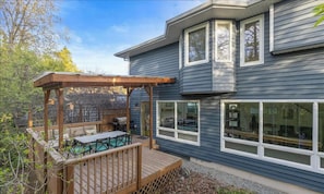 Una casa moderna con terraza, pérgola y zona de barbacoa.