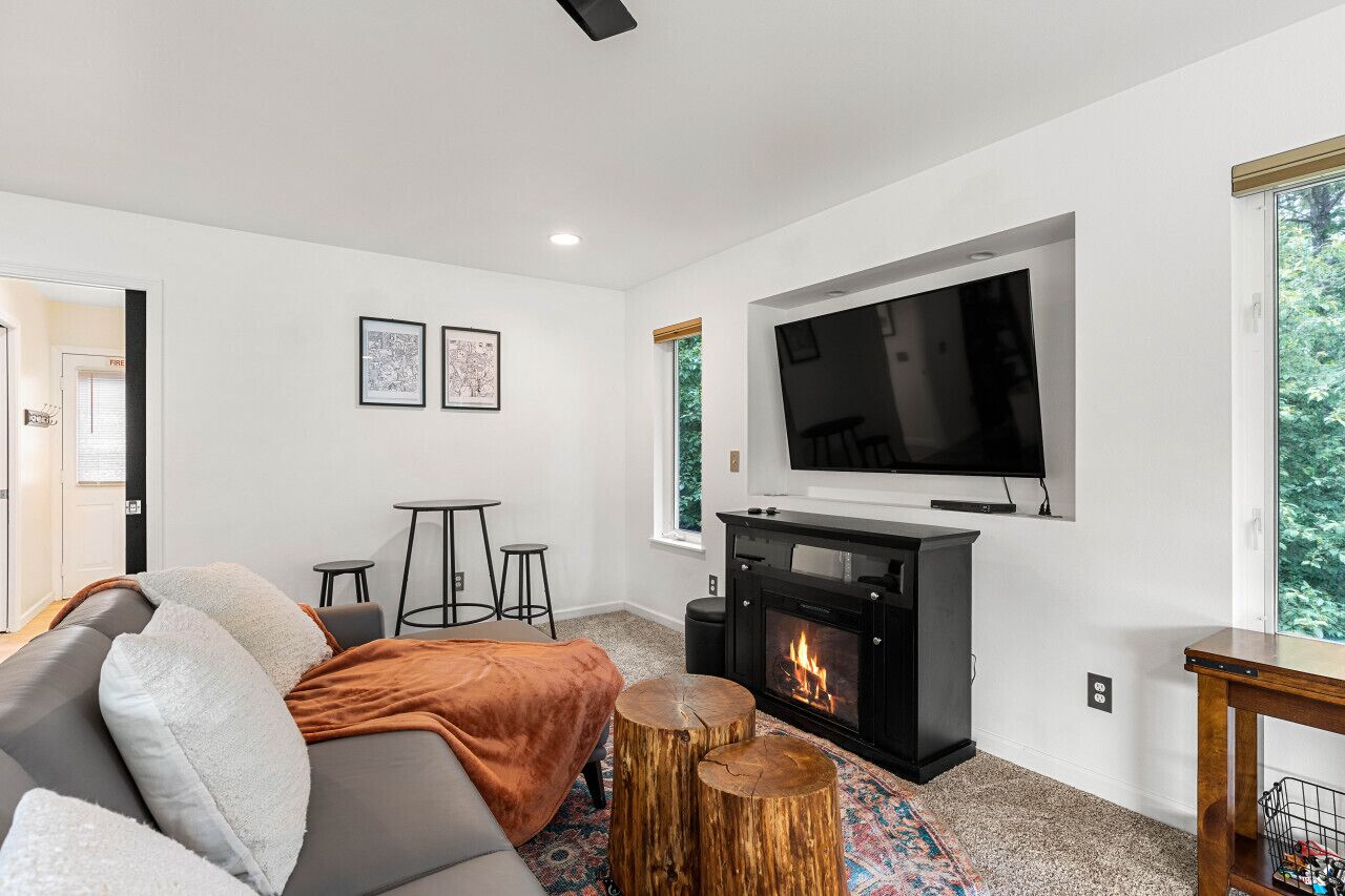 Una sala de estar moderna con chimenea, un sofá, un televisor y una mesita.