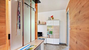 A compact room with a wooden floor, a small desk with a map, a white wardrobe, and a shelf with books and a speaker. - Cozy home in Zeulenroda-Triebes with sauna (Zeulenroda-Triebes)