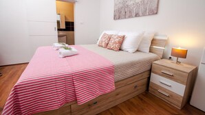 Une chambre à coucher avec un lit, une table de chevet et un tableau au mur.