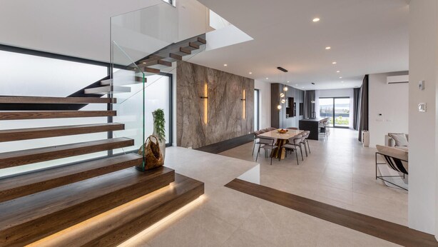 A modern interior with a staircase, a dining area, and a kitchen. - Nice home in Kastel Stari with sauna (Kastel Stari)