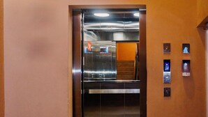 An elevator with a metallic interior and a control panel on the wall. - Jovilee Hotel  (Belize City)