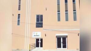 A two-story building with a beige facade, multiple windows, and a sign reading "Jovilee's" at the entrance. - Jovilee Hotel  (Belize City)