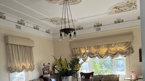 A formal dining room with a large wooden table, upholstered chairs, and a chandelier. - Magnificent historic homestead (Birdwood)