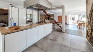 Eine moderne Küche mit Holzarbeitsplatte, Edelstahlgeräten und einem eingebauten Backofen.