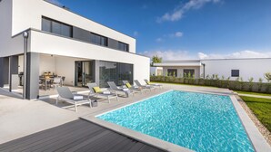 A modern house with a swimming pool, outdoor seating, and a patio area. - Luxurious home in Vodnjan (Vodnjan)