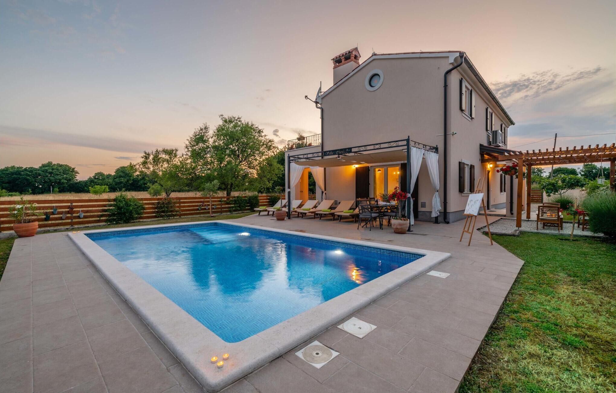Une maison moderne dotée d’une piscine, d’un espace salon extérieur et d’une pergola.