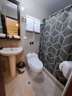 A bathroom with a sink, toilet, and shower curtain. - Real Excelencia (Machu Picchu)