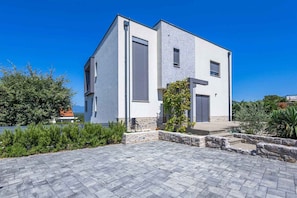 A modern two-story building with a stone pathway leading to the entrance.