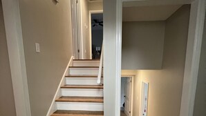 A staircase with wooden steps and white walls.