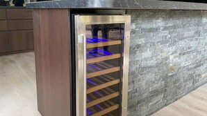 A modern kitchen with a built-in wine cooler featuring a glass door and blue lighting. - 3 bedroom cozy home in Gotlands Tofta (Gotlands Tofta)