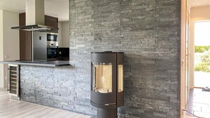 A modern kitchen with a stone wall, a built-in oven, and a black stove. - 3 bedroom cozy home in Gotlands Tofta (Gotlands Tofta)