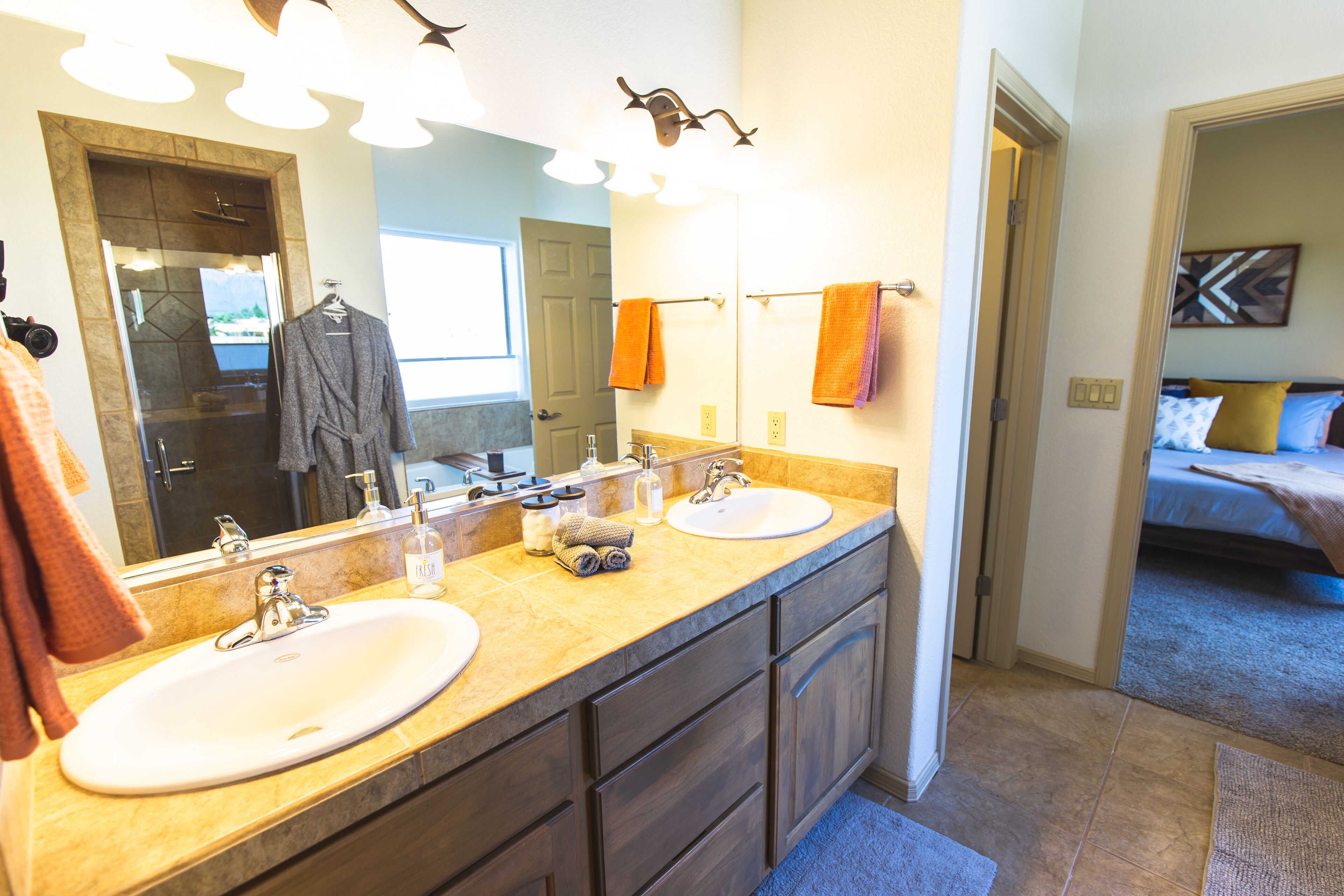 A bathroom with two sinks, a large mirror, and a shower area.