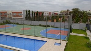 A rooftop sports facility with a basketball court and a swimming pool. - Modern 2 Bedroom Duplex - Gated Estate , 24/7 Security, Gym, Pool, Tennis Court (Tema)