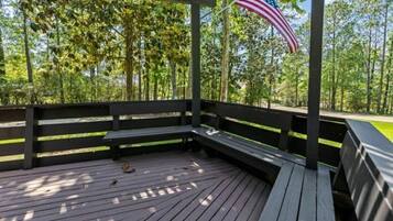 Un'area esterna coperta con un pavimento in legno, panche e una bandiera americana.