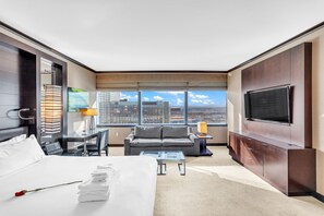 Relax in comfort with a large bed, flat-screen TV, and seating area offering a city view.