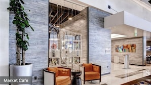 A modern interior with a seating area, a glass display case, and a plant.