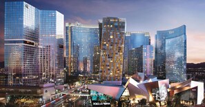 A cityscape with modern high-rise buildings, including a prominent curved structure with a large digital billboard.