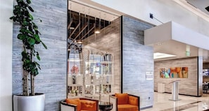 A modern interior with a seating area, a glass display case, and a plant.