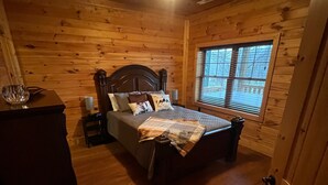 A wooden-paneled bedroom with a bed, a nightstand, a dresser, a window with blinds, and a ceiling fan. - 2 Acres of pure paradise with amazing Mountain View’s!! Minutes from Emory&Henry (Meadowview)