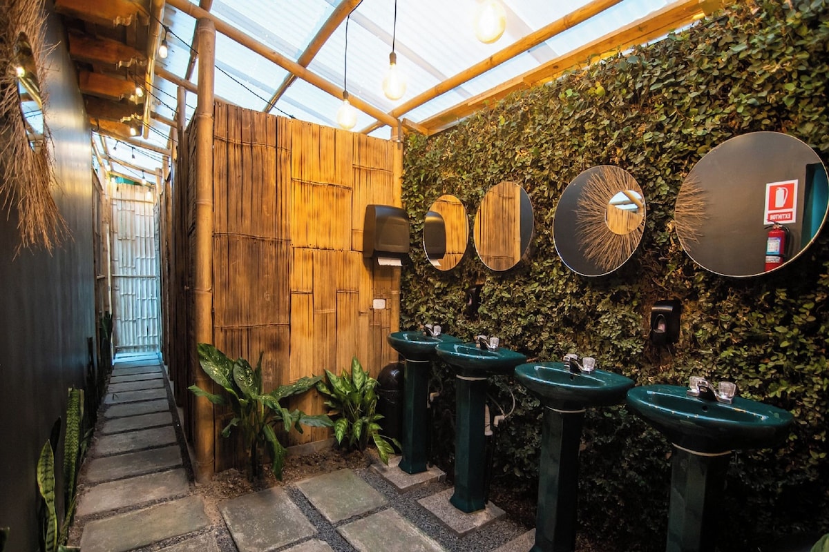 A restroom with wooden walls, green plants, and multiple sinks.