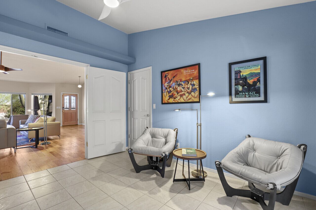 A room with two leather armchairs, a small round table, and a door leading to another room.