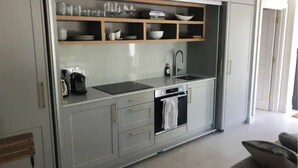 Een moderne keuken met een ingebouwde vaatwasser, een koffiezetapparaat en een spoelbak.