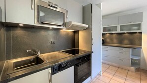 Una cocina moderna con electrodomésticos de acero inoxidable, horno integrado y lavavajillas.