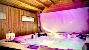 Une cabane en bois dotée d’un jacuzzi, de murs en bois, d’une fenêtre et d’un panneau de commande.