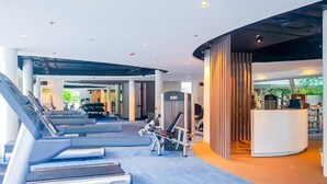 A modern gym with treadmills, weight machines, and a reception area.