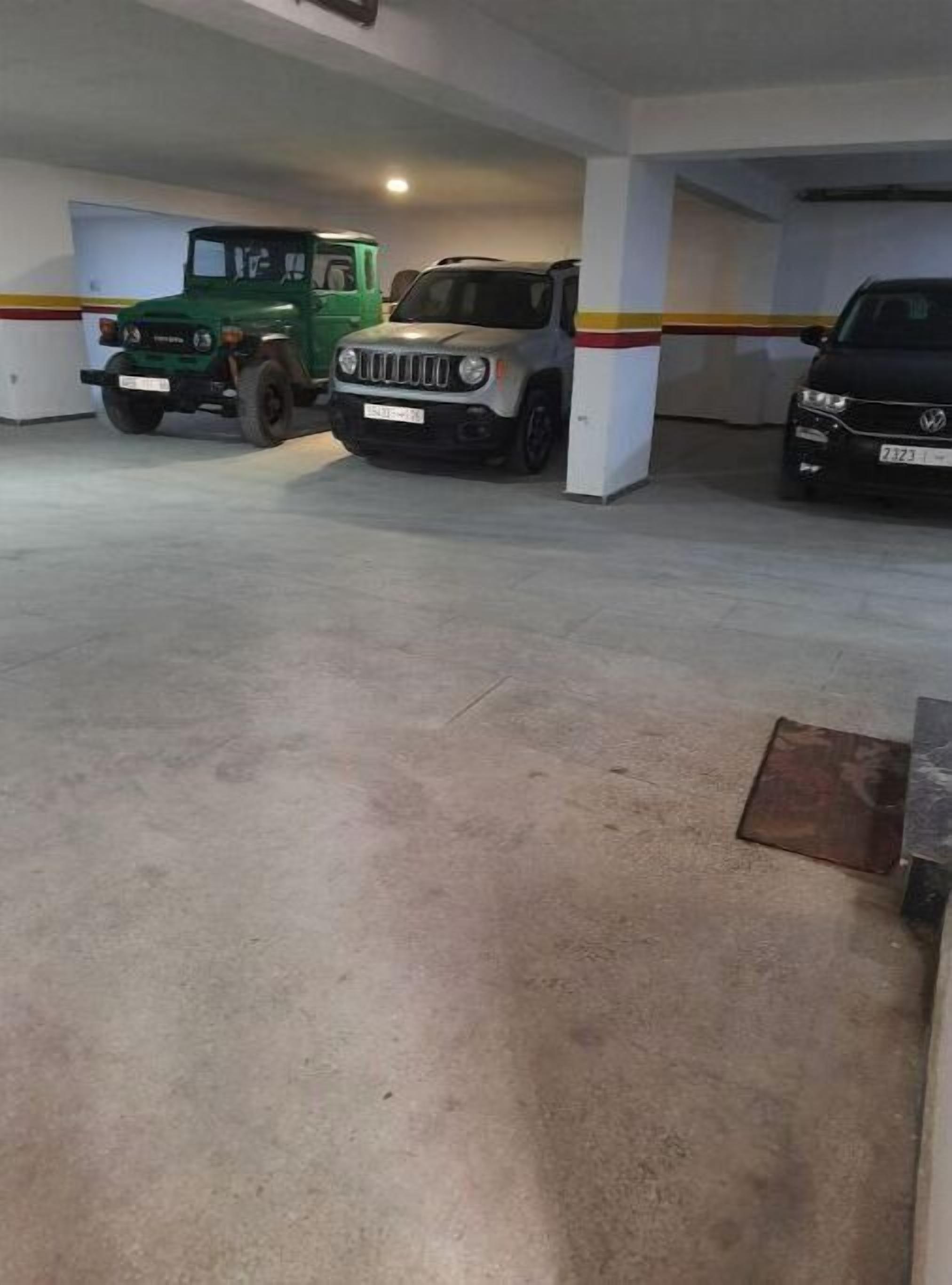 Eine Parkgarage mit drei Fahrzeugen in markierten Stellplätzen.