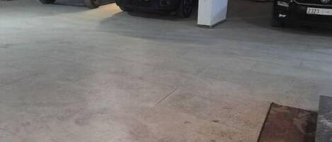 A parking garage with three vehicles parked in designated spaces.